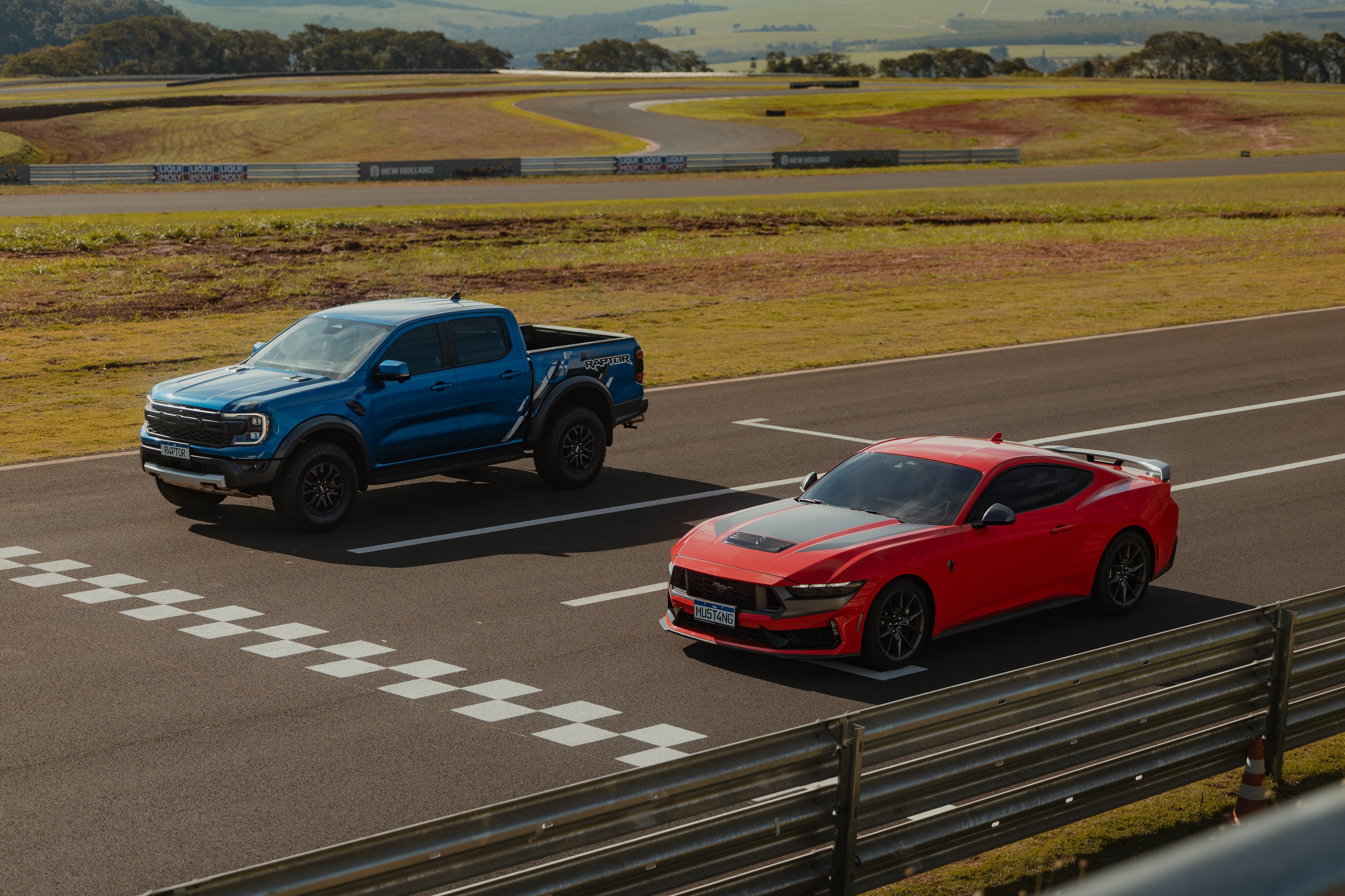 Ford Mustang Dark Horse vermelho na pista com uma Ford Ranger Raptor azul